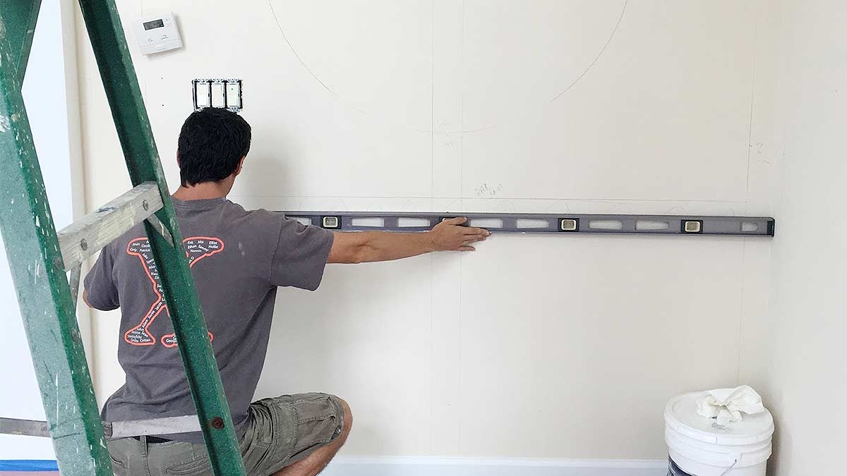 Carpenter measuring for a wall mirror